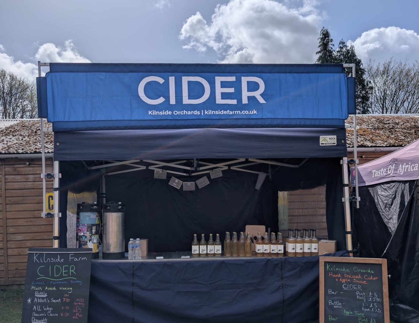 The Kilnside Orchards cider stall with its blue CIDER banner and chalkboards